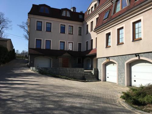 a large house with two garage doors on a street at Apartamenty AP 12 in Częstochowa