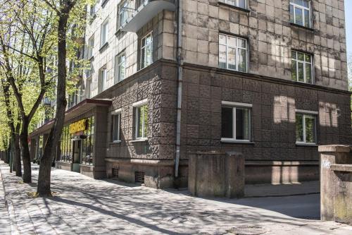 a brick building on a street next to a tree at Old Town River Apartments in Klaipėda