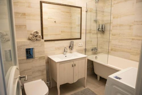 a bathroom with a sink and a toilet and a bath tub at Old Town River Apartments in Klaipėda