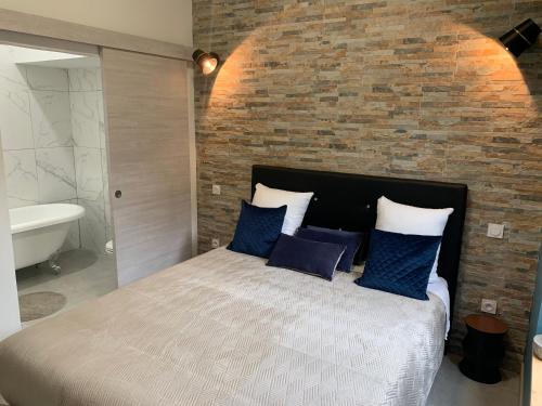 ein Schlafzimmer mit einem großen Bett und einer Ziegelwand in der Unterkunft LE 31 in Carcassonne