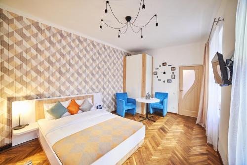 リヴィウにあるStyle apartments in old Lvivのベッドルーム1室(ベッド1台、テーブル、青い椅子付)