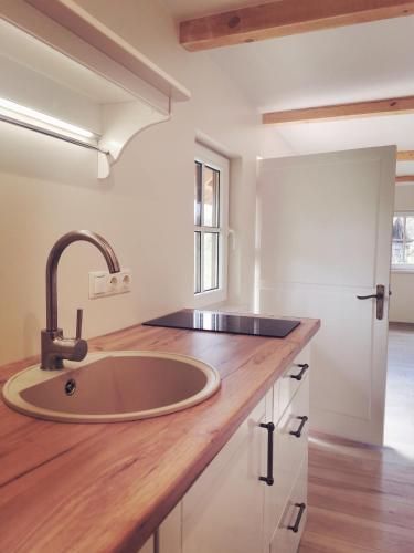 a sink in a kitchen with a wooden counter top at Pape holiday home in Pape
