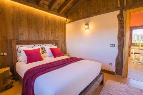 a bedroom with a large white bed with red pillows at El BURGO DE OSMA ALOJAMIENTO RURAL VILLA BAGH in El Burgo de Osma