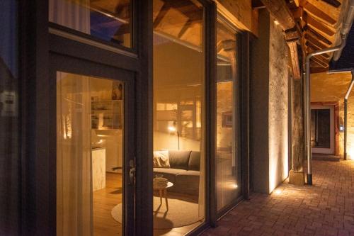 バート・クロツィンゲンにあるBaumgartners Dreiseithof - historisch, modern, zentralのガラスの引き戸付きの部屋、リビングルームが備わる客室です。