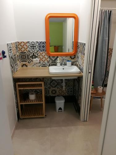 a bathroom with an orange mirror and a sink at 2 LOFTS guest house in Turin