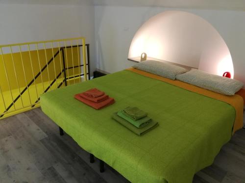 a bedroom with a green bed with two towels on it at 2 LOFTS guest house in Turin