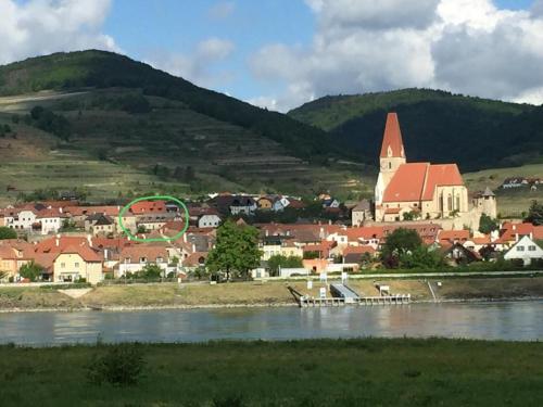 a town next to a river with a church at Apartment Kirchenblick in Weissenkirchen in der Wachau