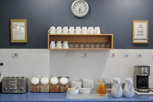 a kitchen with a counter with a clock on the wall at City Motor Inn in Toowoomba