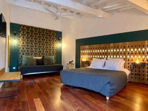 une chambre avec un grand lit et un canapé dans l'établissement La Paillère chambres d hôtes, à Mus