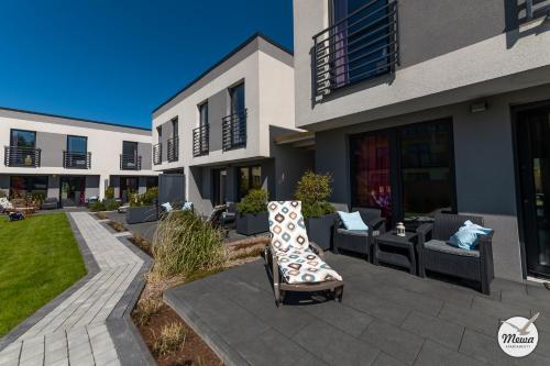 a patio with couches and chairs in front of a building at Apartamenty Mewa in Jastrzębia Góra