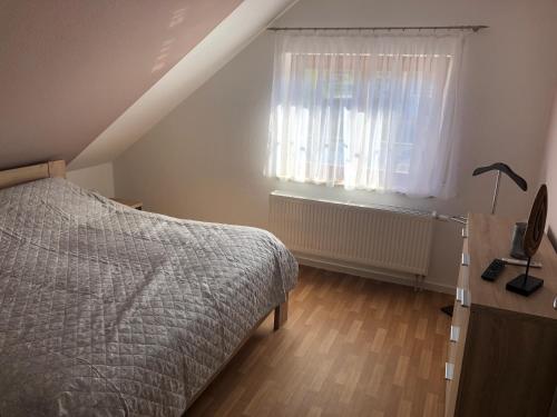 Schlafzimmer mit einem Bett und einem Fenster in der Unterkunft Ferienwohnung Kleistring in Obernkirchen