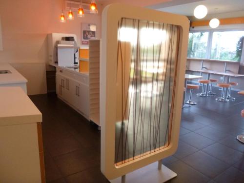 a kitchen with a large window in the middle of a room at ibis budget Narbonne Sud A9/A61 in Narbonne