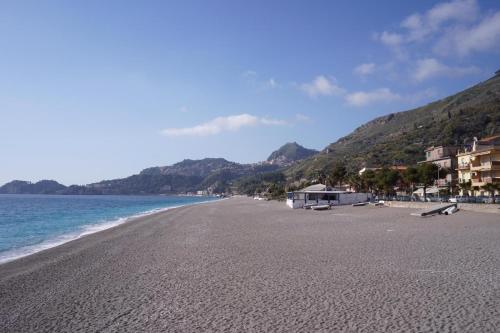 a view of a beach with houses and the ocean at vacanza Taormina mare in Mazzeo