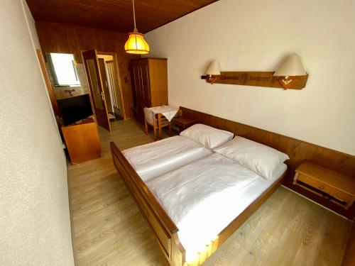 a bedroom with a white bed in a room at Pension Pöchhacker in Gresten