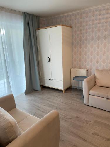 uma sala de estar com um sofá e um armário em NEW!! Melluzi Appartment em Jūrmala