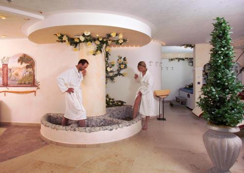 two people standing in a bath tub in a room at Residence Palmai in Ortisei