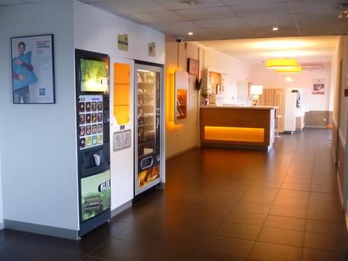 a hallway with two vending machines and a counter at ibis budget Narbonne Sud A9/A61 in Narbonne