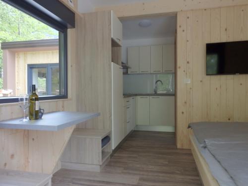 a kitchen with wooden walls and a large window at Small holiday houses in Ajdovščina