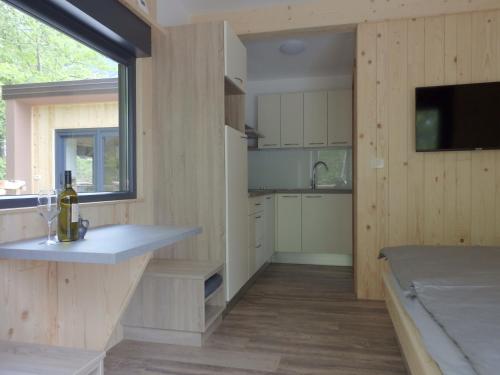 uma cozinha com paredes de madeira e uma grande janela em Small holiday houses em Ajdovščina