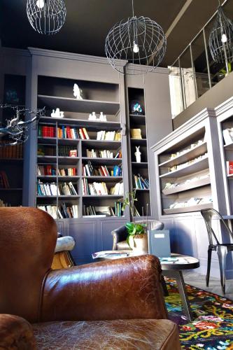 a living room with a leather couch and a book shelf at Best Western Citadelle in Besançon