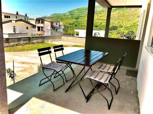 einen Tisch und Stühle auf einem Balkon mit Aussicht in der Unterkunft Eco lodge apartment in Bar