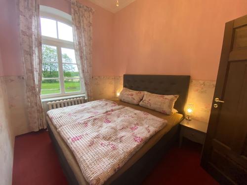 a small bedroom with a bed with a window at Exklusive Ferienwohnungen im Gutshaus Viezen in Bernitt
