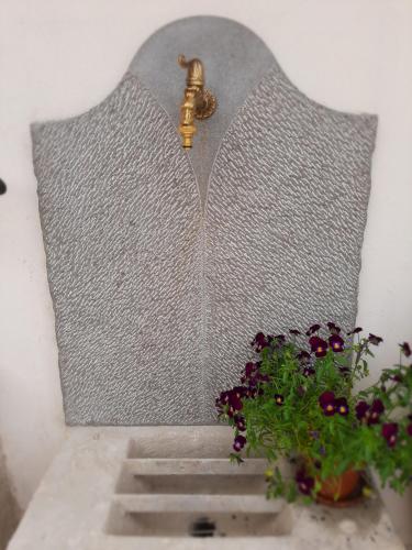 a metal wall with a faucet next to a plant at Dvor Vipolže in Dobrovo