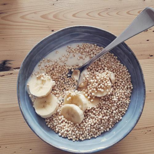 a bowl of food with seeds and bananas and a spoon at Dvor Vipolže in Dobrovo