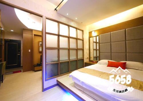 a bedroom with a bed and a large window at 85 Cape Inn in Kaohsiung