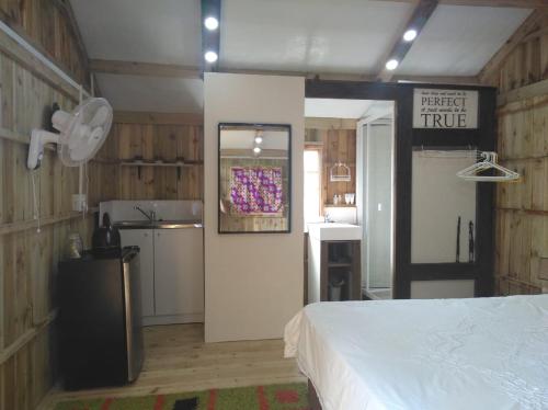 een slaapkamer met een wit bed en een keuken bij African Sky's the Limit - Budget, Quiet, Peaceful Self-Catering in Durban
