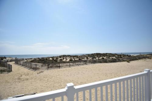 a view of a beach with a white fence at Ocean Club 4011 townhouse in Ocean City