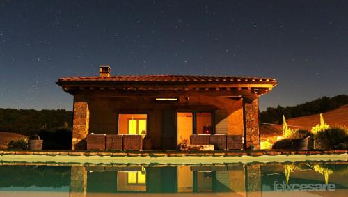 a small building next to a swimming pool at night at Argillosa Country House in Marsiliana