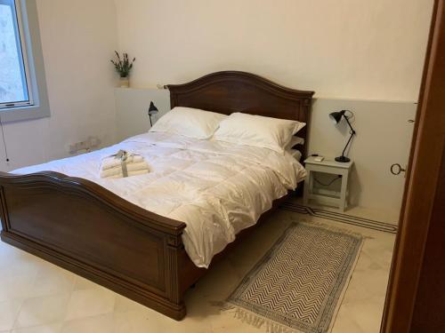 een slaapkamer met een groot bed met een houten hoofdeinde bij Luxury Valletta Apartment in Valletta