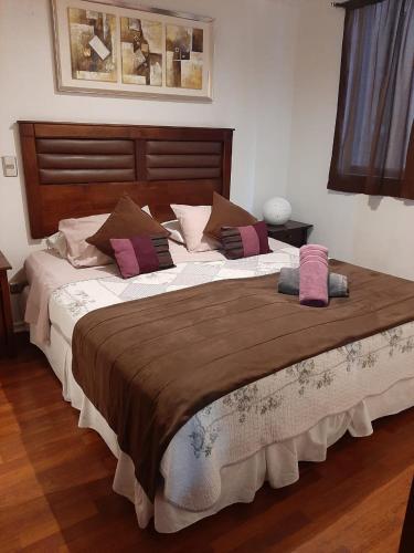 a large bed with pillows on it in a bedroom at America Departamentos in Santiago