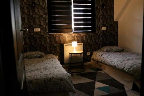 a bedroom with two beds and a lamp on a tiled floor at Ilot Désille in Boulogne-sur-Mer