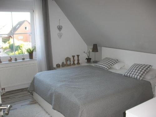a white bedroom with a bed and a window at Ferienwohnung Ott in Amelinghausen