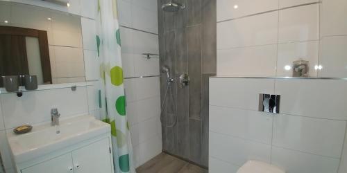 a bathroom with a shower and a sink at Dom Wczasowy FALA in Darłówko