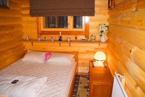 a bedroom with a bed in a log cabin at Kettu Holl Cottage in Taipalsaari