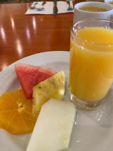 a plate of fruit and a glass of orange juice at Scotch Arms Mews Bed & Breakfast in Brampton