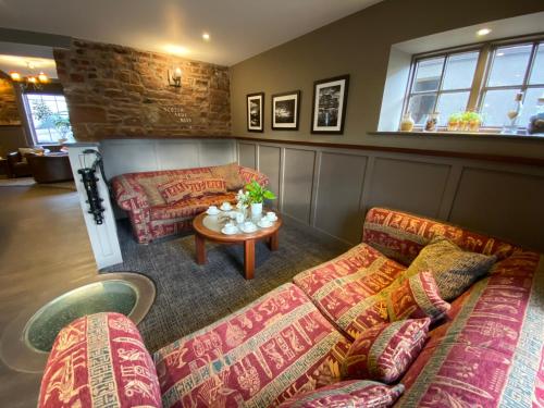 een woonkamer met 2 banken en een tafel bij Scotch Arms Mews Bed & Breakfast in Brampton