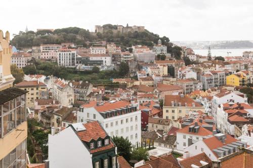a view of a city with buildings and a castle at Panoramic Graça Duplex with Castle and River Views by NestAtLisbon in Lisbon