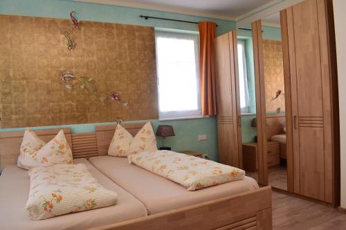 1 dormitorio con 1 cama con 2 almohadas en Wagners Aparthotel, en Sasbachwalden