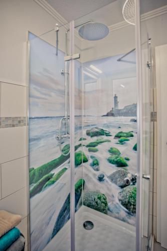 a bathroom with a shower with a painting of the ocean at Kleine Auszeit in Bad Segeberg