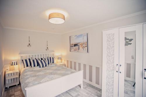 - une chambre avec un lit blanc et des oreillers bleus dans l'établissement Kleine Auszeit, à Bad Segeberg