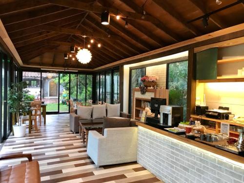 a living room with couches and a kitchen with windows at My Chateau Resort in Kenting