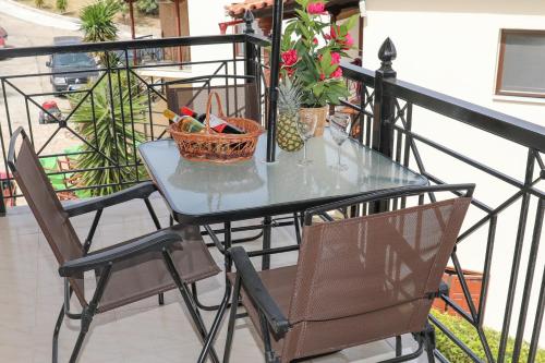 a glass table and chairs on a balcony at Chrissomallis Apartments in Skiathos Town