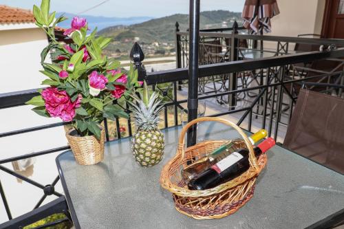 a table with a basket and flowers on a balcony at Chrissomallis Apartments in Skiathos Town