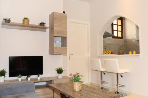 a living room with a tv and a table at Chrissomallis Apartments in Skiathos Town