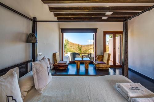 a bedroom with a bed and a living room at La Almendra y El Gitano in Agua Amarga