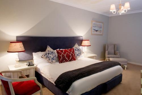 a bedroom with a large bed with red and blue pillows at CedarWoods of Sandton in Sandton